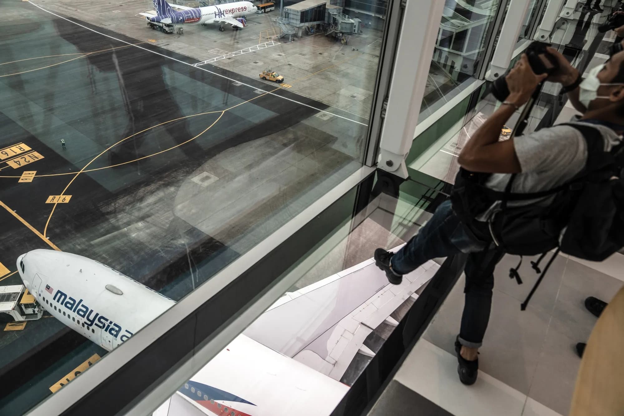 An airplane taxiing under the airport Sky Bridge near gates 13-22